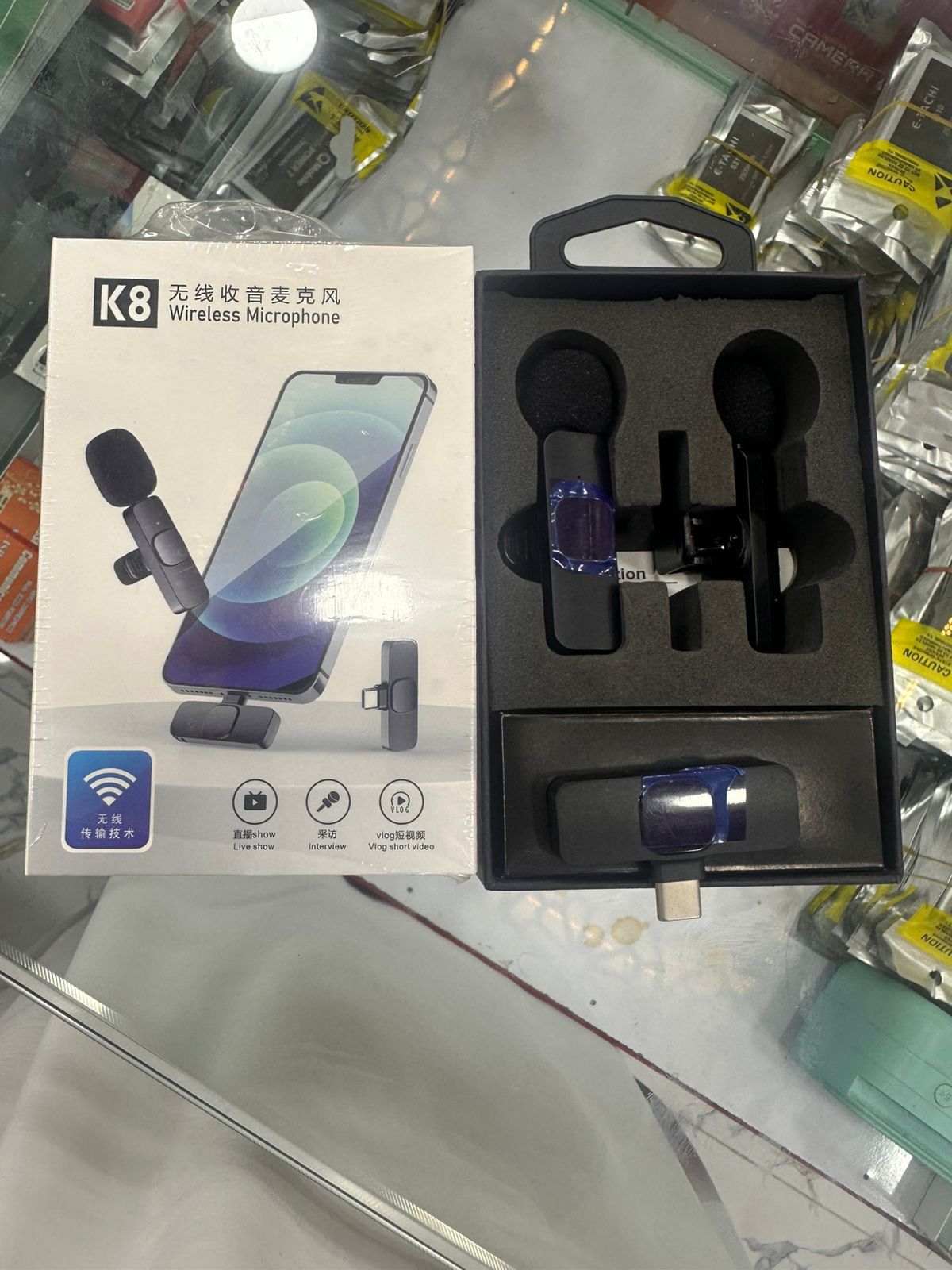 K8 wireless microphone set with packaging on a reflective surface