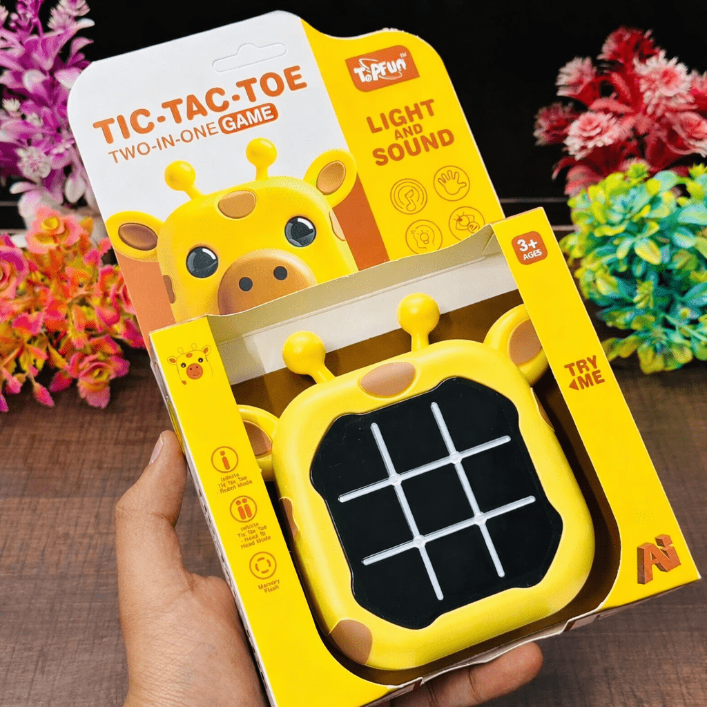 Yellow giraffe-shaped tic-tac-toe game with light and sound feature, held in a hand against a floral background.