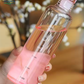 Clear bottle with pink gradient held by a hand against a blurred background 500ml Glass