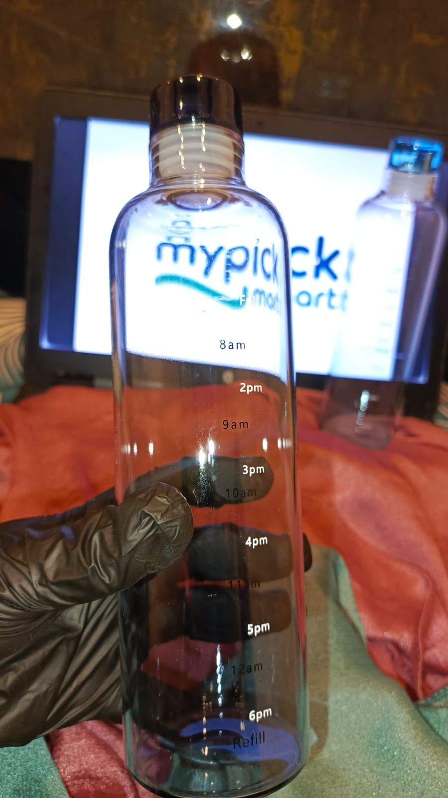 Bottle with measurement markings held by a gloved hand, with a blurred background Aesthetic Bottle