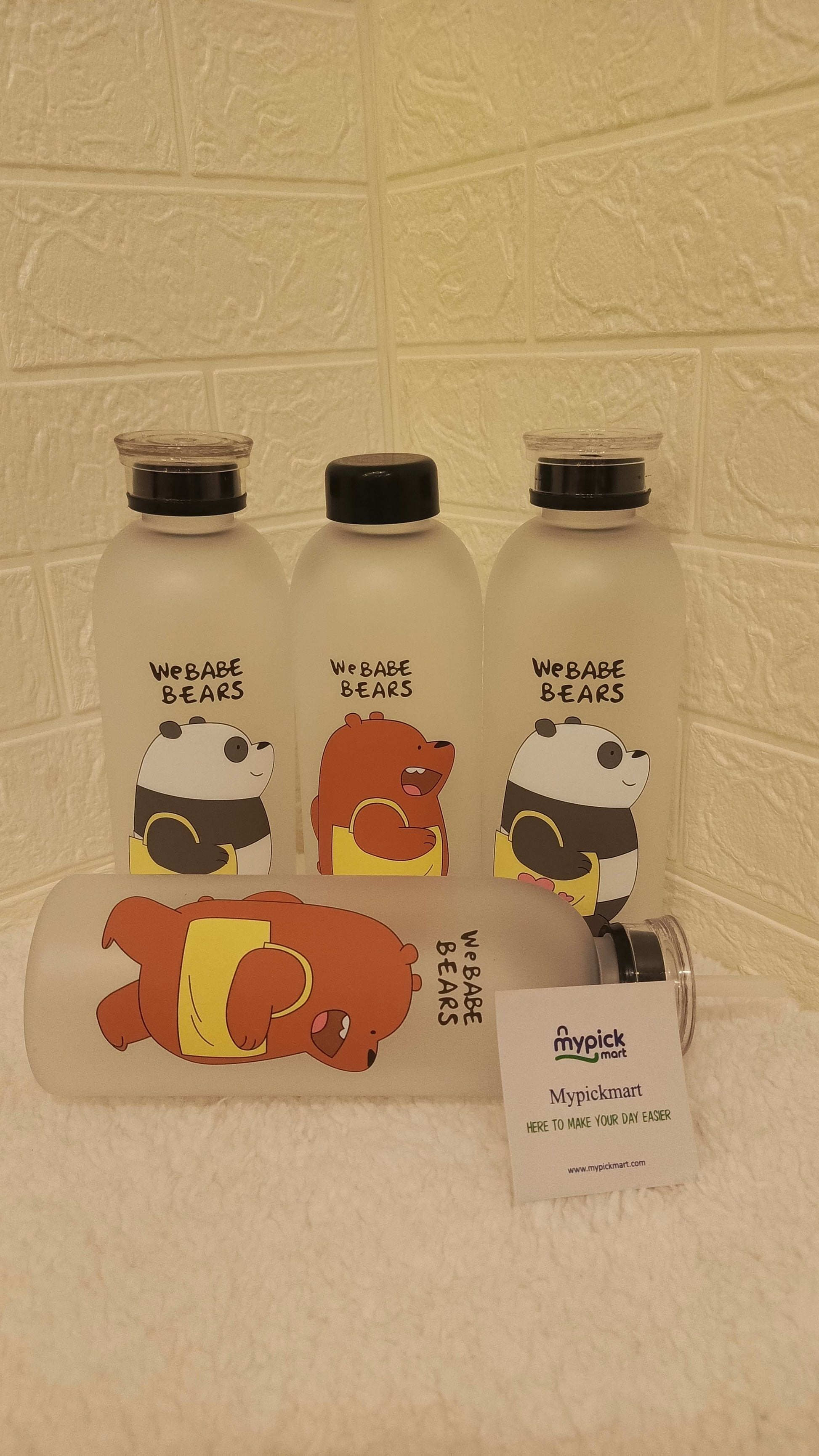Three bottles with bear-themed labels on a textured wall background
