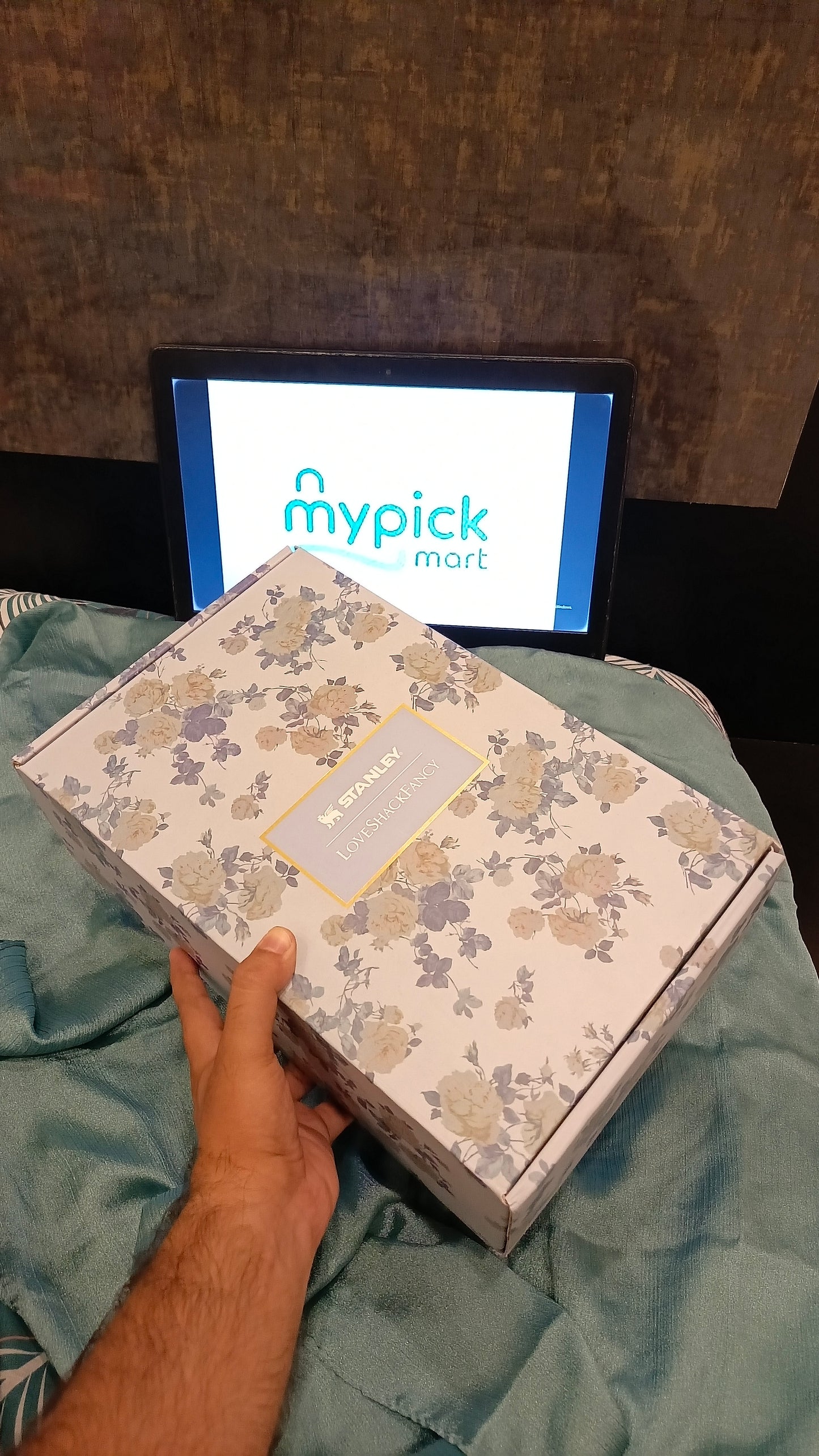 Floral-patterned box held by a hand with 'mypick mart' screen in the background